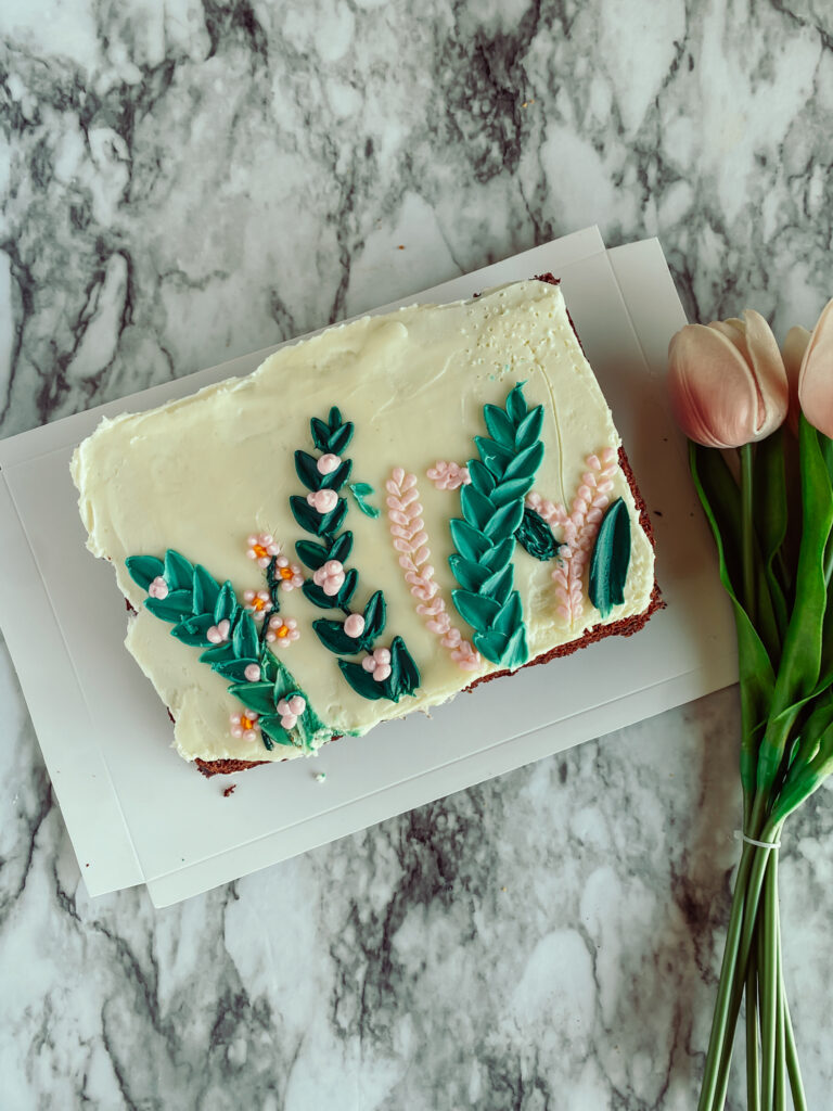 succulent with pink buttercream decorated cake 