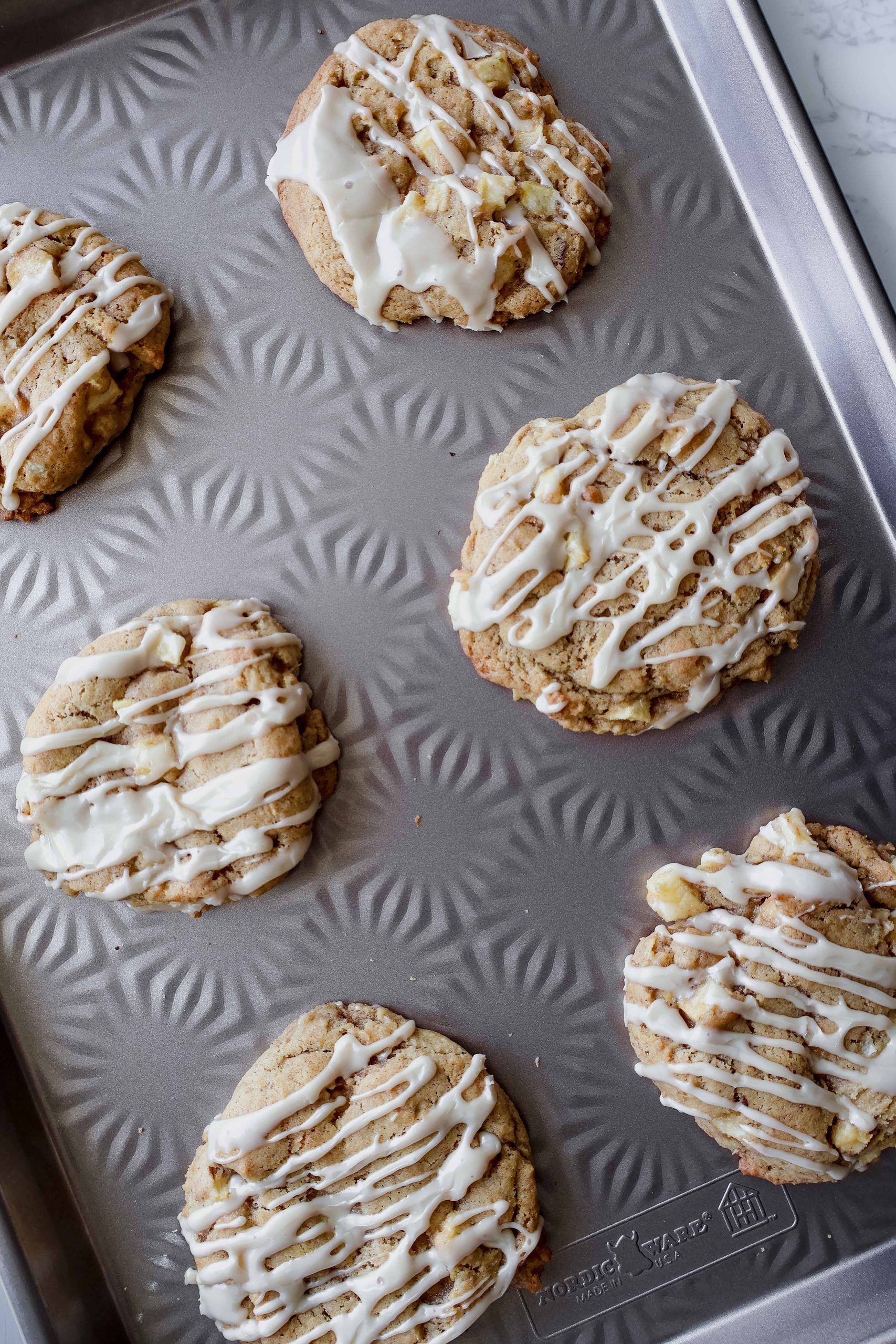 apple fritter cookie with maple glaze on a cookie sheet